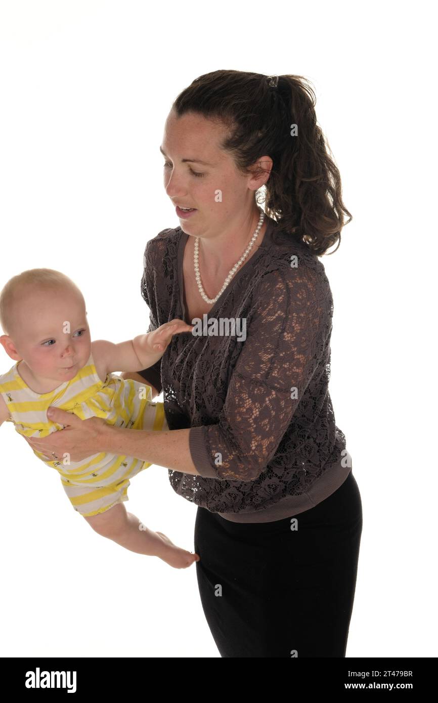 Madre y bebé felices de pie balanceándose en brazos Foto de stock