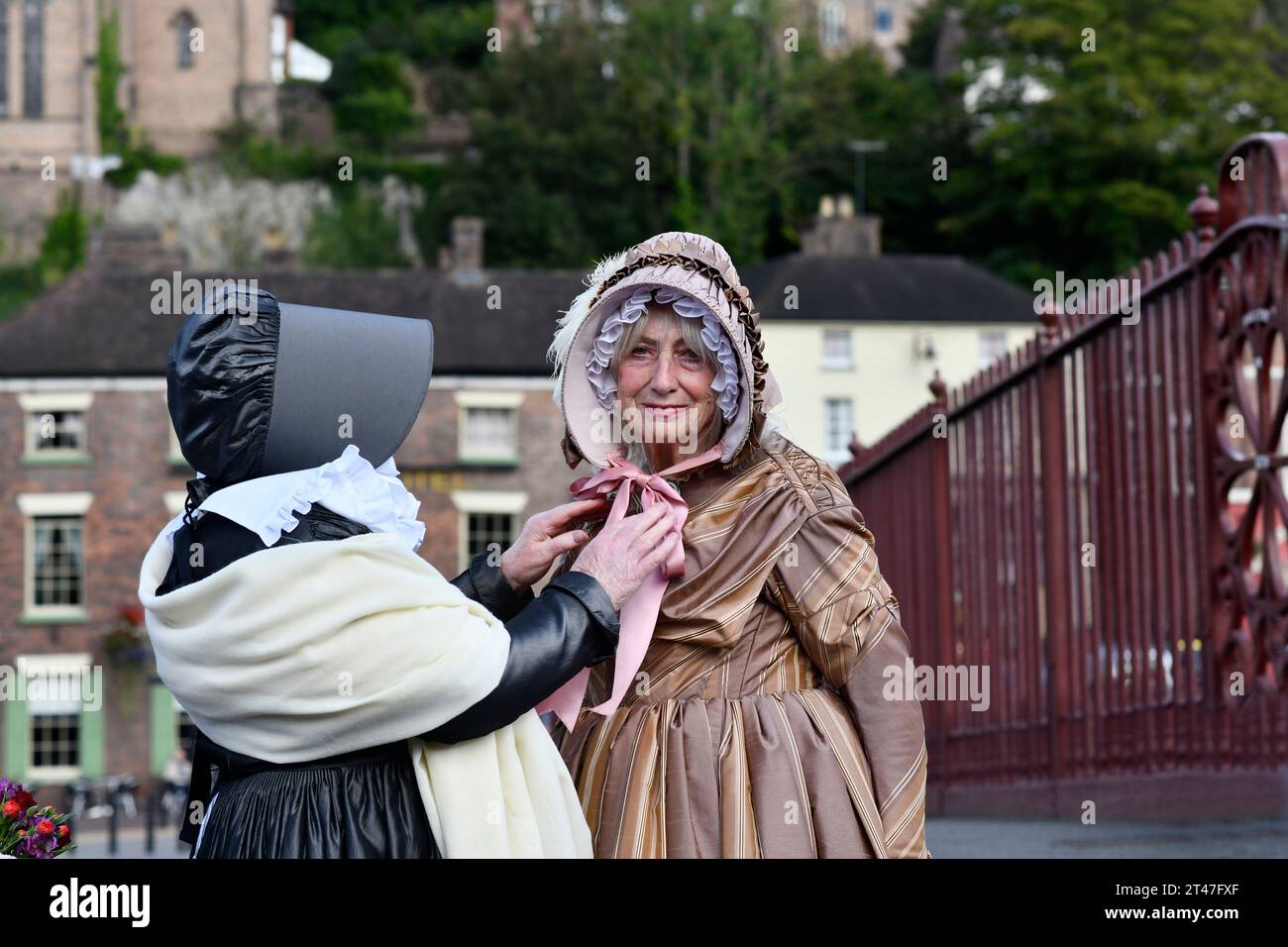Señoras en trajes de época victoriana en Ironbridge, Shropshire, Patrimonio de la Humanidad de la UNESCO, Inglaterra, Reino Unido. Campaña por la restauración de fuentes. Foto de stock