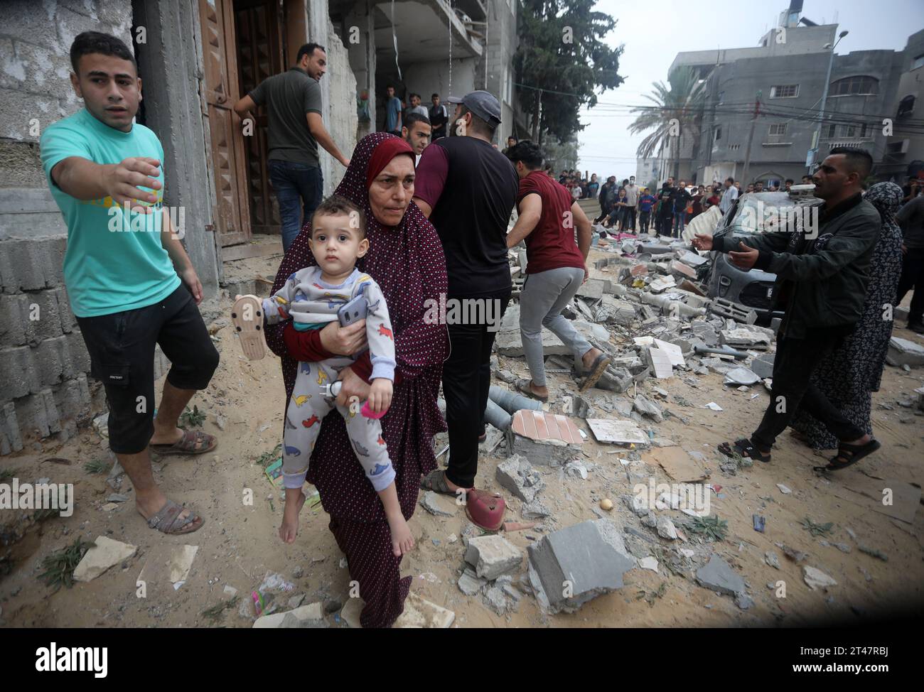 Rafah, Gaza. 28º de octubre de 2023. Una mujer palestina lleva un bebé después de los bombardeos israelíes contra la familia houes de AL-mgary en Rafah, en el sur de la Franja de Gaza, el domingo 29 de octubre de 2023. Israel golpeó a Gaza con más ataques aéreos y terrestres el 29 de octubre en una escalada de campaña militar cuando la ONU advirtió que el orden civil estaba 'empezando a derrumbarse' en el asediado territorio palestino. Foto de Ismael Mohamad/UPI. Crédito: UPI/Alamy Live News Foto de stock