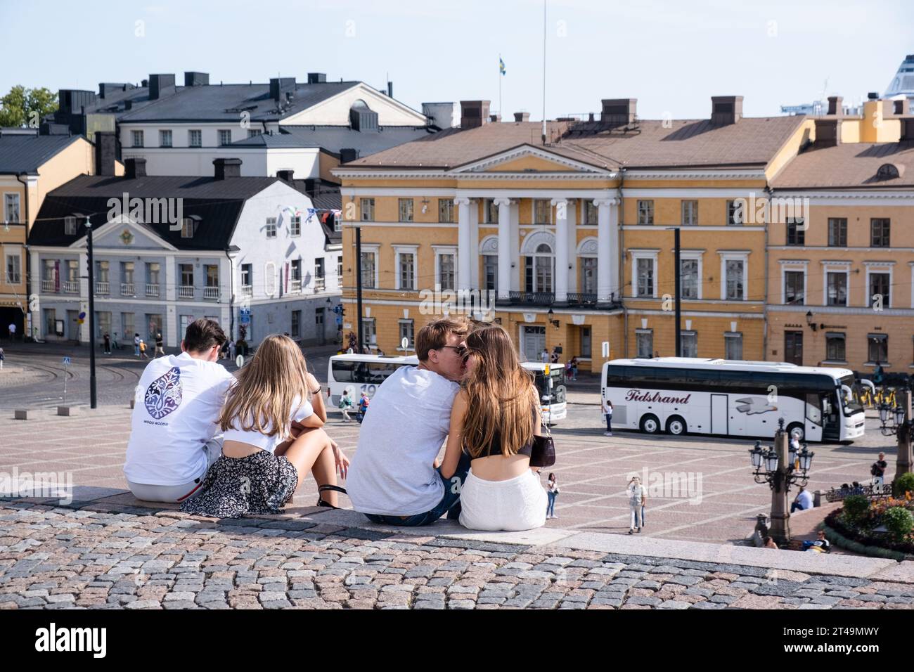 CATEDRAL, PLAZA DEL SENADO, HELSINKI: Parejas jóvenes en los escalones de la Catedral de Helsinki y la Plaza del Senado en verano en el centro de Helsinki, Finlandia. Foto de stock