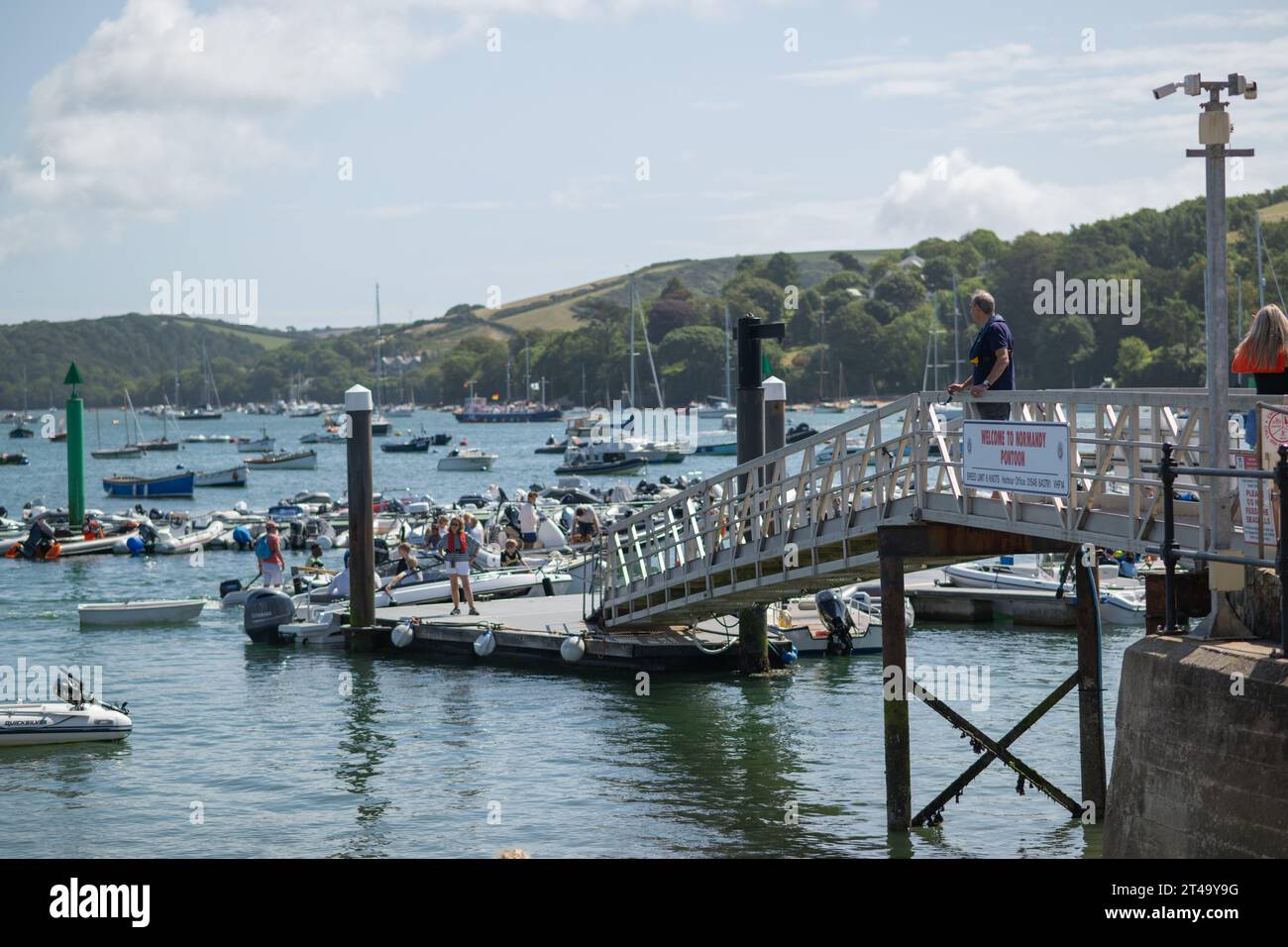 Salcombe Harbour, de Whitestrand en un día de verano con cielo azul y nubes blancas, mostrando embarcaderos, yates amarrados y East Portlemouth en el fondo Foto de stock