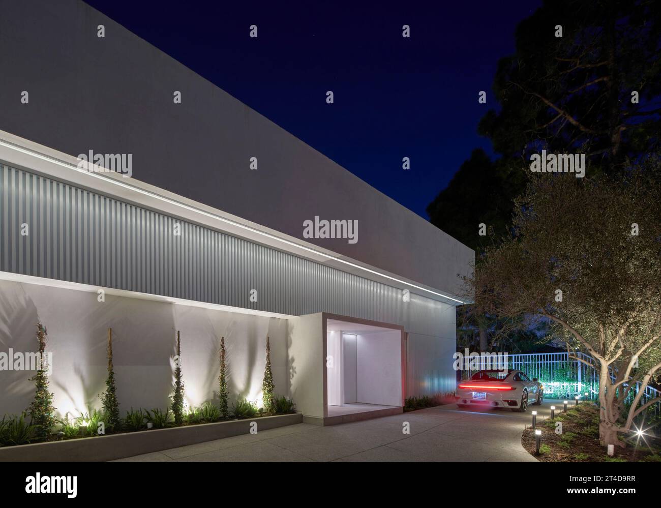 Vista exterior al atardecer con Porsche. Oceanus House, Los Ángeles, Estados Unidos. Arquitecto: Pierre De Angelis, 2023. Foto de stock