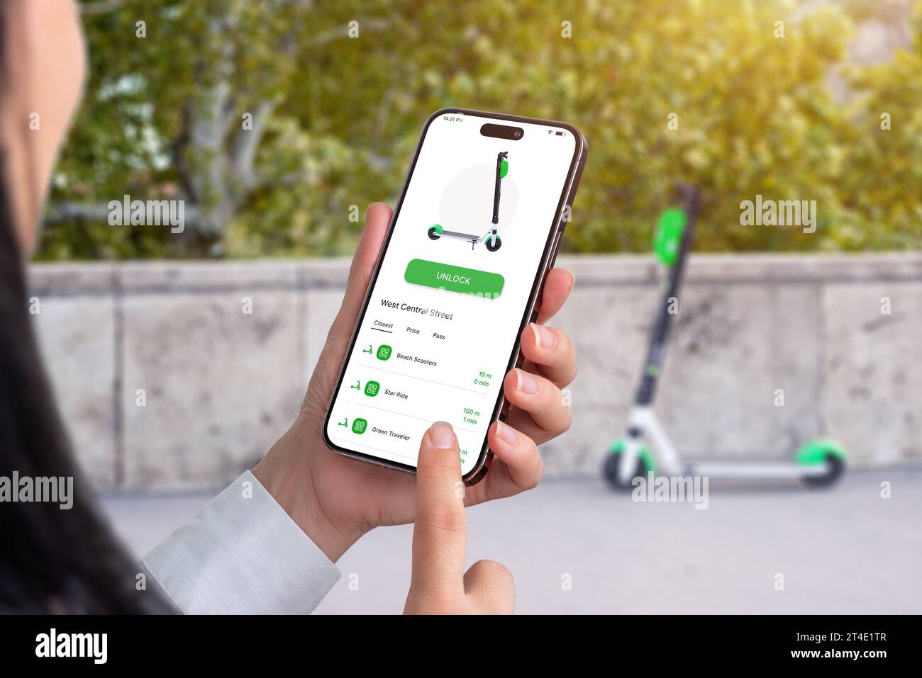 Alquiler de un scooter eléctrico con una aplicación, con teléfono móvil. Scooter que es desbloqueado por la aplicación en segundo plano Foto de stock