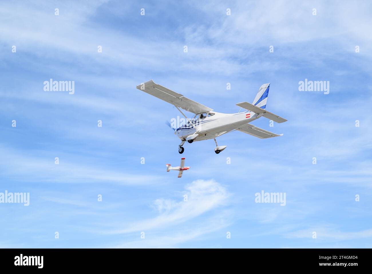 Avión ultraligero de un solo motor volando en el cielo azul con nubes blancas Foto de stock