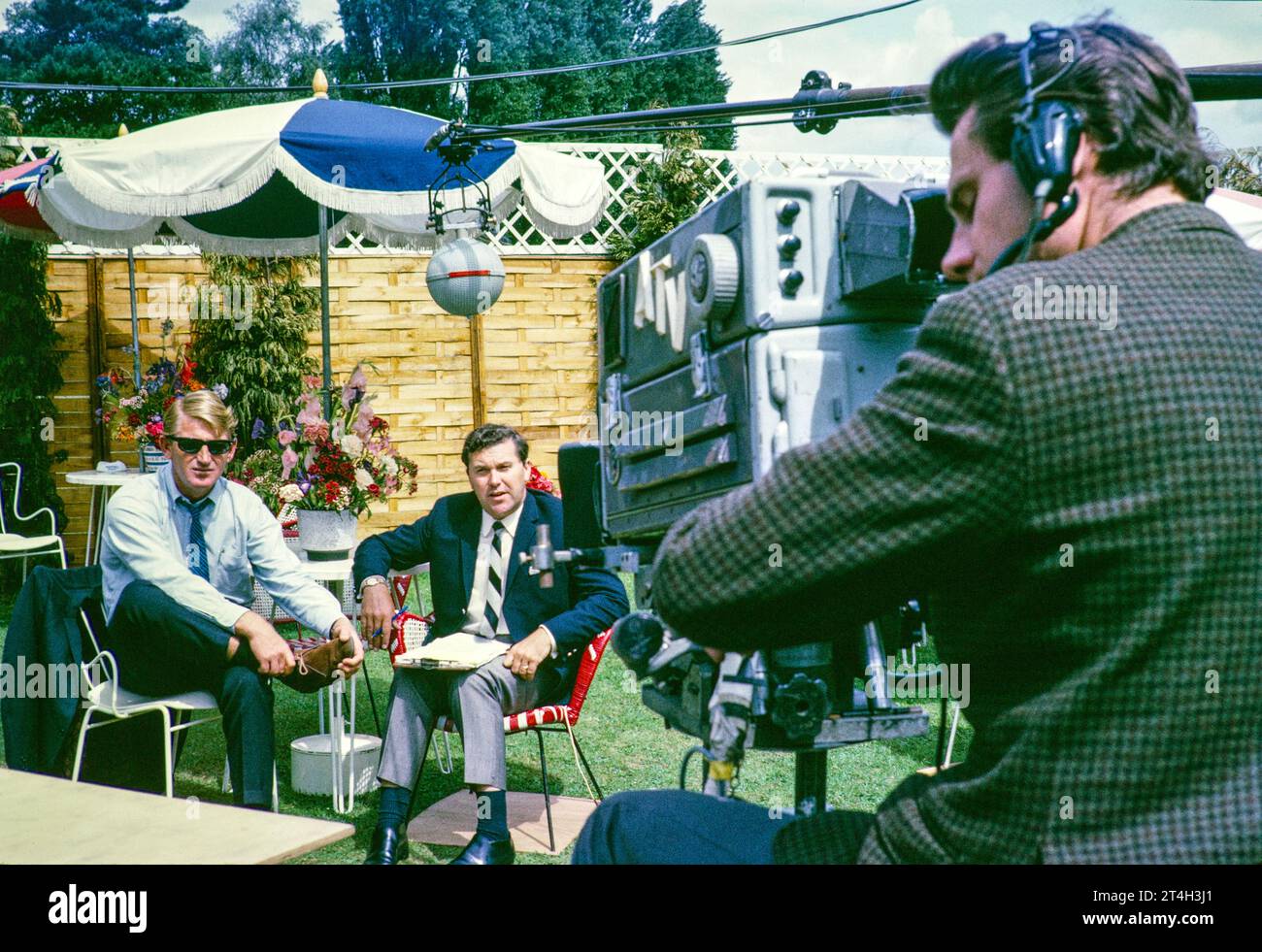 ATV televisión ITV fuera de la transmisión, torneo de tenis Wimbledon, Inglaterra, Reino Unido 1967 Dickie Davies con el jugador de tenis australiano Lew Hoad camarógrafo Jeff Joyce. Foto de Alan 'Taffy' Harries Foto de stock