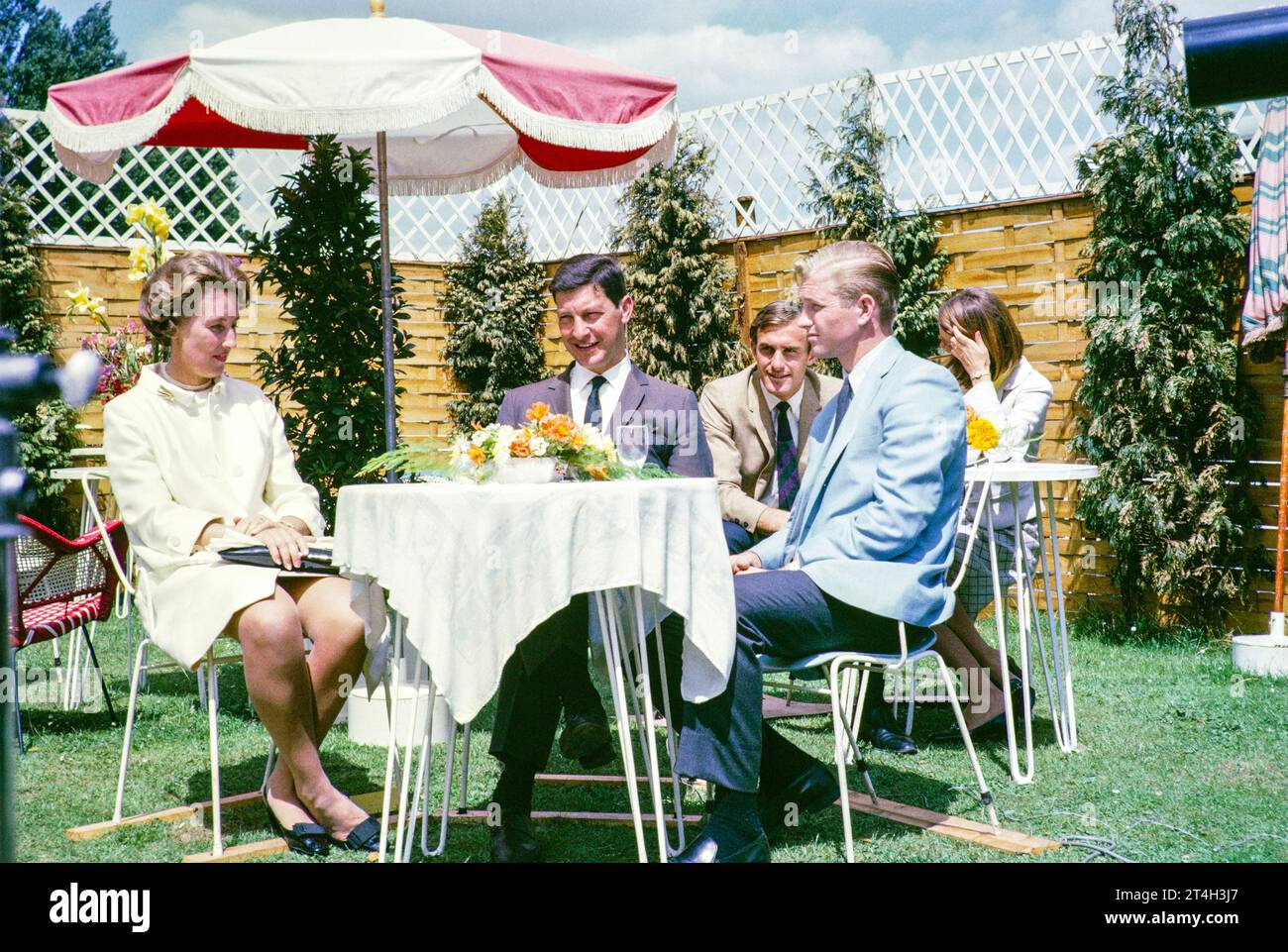 ATV Televisión ITV fuera de la transmisión, torneo de tenis Wimbledon, Inglaterra, Reino Unido 1967. La tenista Angela Mortimer y el entrevistador Peter Lorenzo. John Newcombe jugador de tenis en el fondo. Foto de Alan 'Taffy' Harries Foto de stock