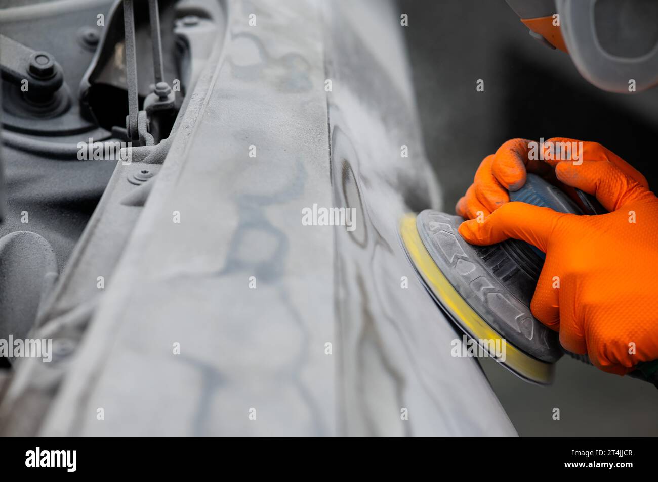 Renovación de un coche de accidente poniendo la masilla para suavizar los  arañazos antes de pintar Fotografía de stock - Alamy
