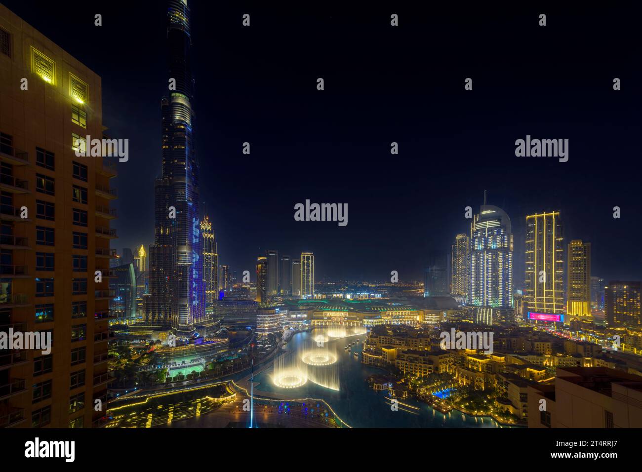 Vista nocturna aérea de alto ángulo del centro de Dubai, con el Dubai Mall, tiendas y fuente iluminada bajo el rascacielos Burj Khalifa en Dubai EAU. Foto de stock