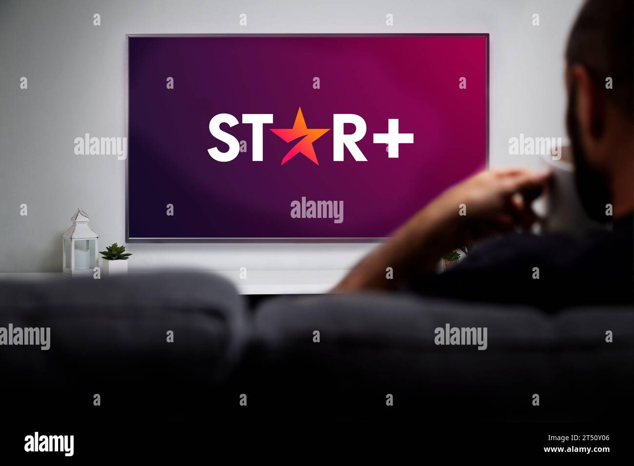 Star Plus en la televisión inteligente. Hombre con una taza y viendo la