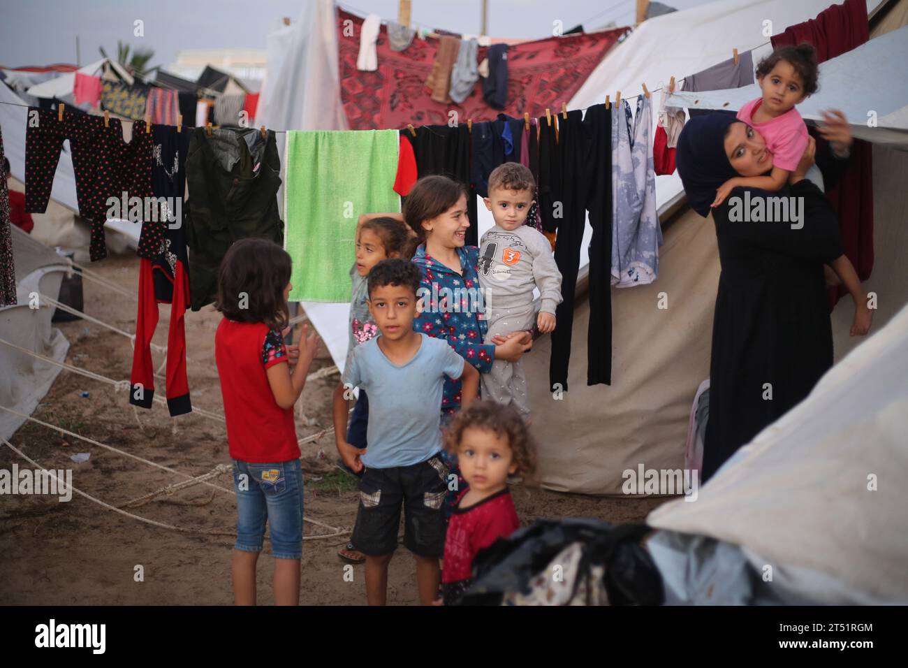 Los niños palestinos desplazados juegan entre las tiendas de campaña que se establecieron como refugios en un centro administrado por las Naciones Unidas, en Jan Yunis, en el sur de la Franja de Gaza. En medio de las batallas en curso entre Israel y el grupo palestino Hamas. Israel golpeó Gaza, gobernada por Hamás, el 29 de octubre, en una creciente campaña aérea y terrestre, mientras la ONU advirtió que el orden civil estaba "empezando a derrumbarse" en el asediado territorio palestino. Miles de civiles, tanto palestinos como israelíes, han muerto desde el 7 de octubre de 2023, después de que militantes palestinos de Hamás con base en la Franja de Gaza entraran al sur de Israel en una forma inédita Foto de stock