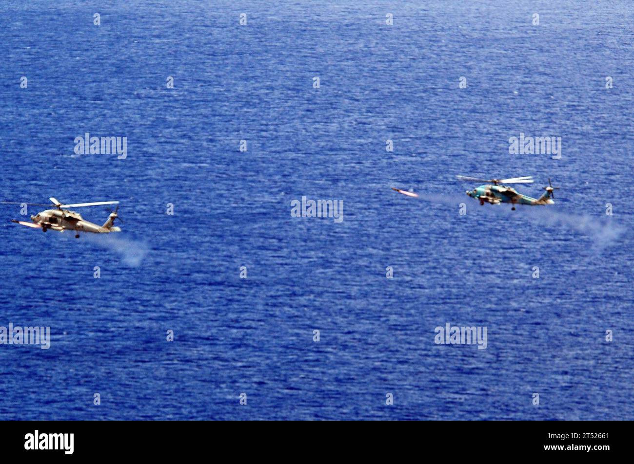 0908307647G-117 OCEANO PACÍFICO (30 de agosto de 2009) Dos helicópteros HAWK HASH-60H, asignados al Escuadrón Antisubmarino de los Indios del Helicóptero (HS 6), disparan misiles AGM-114 Hellfire vivos al alcance de Oki Daito Jima. El HS-6 forma parte de Carrier Air Wing Eleven (CVW-11) y se embarca a bordo del portaaviones USS Nimitz (CVN 68). Marina Foto de stock