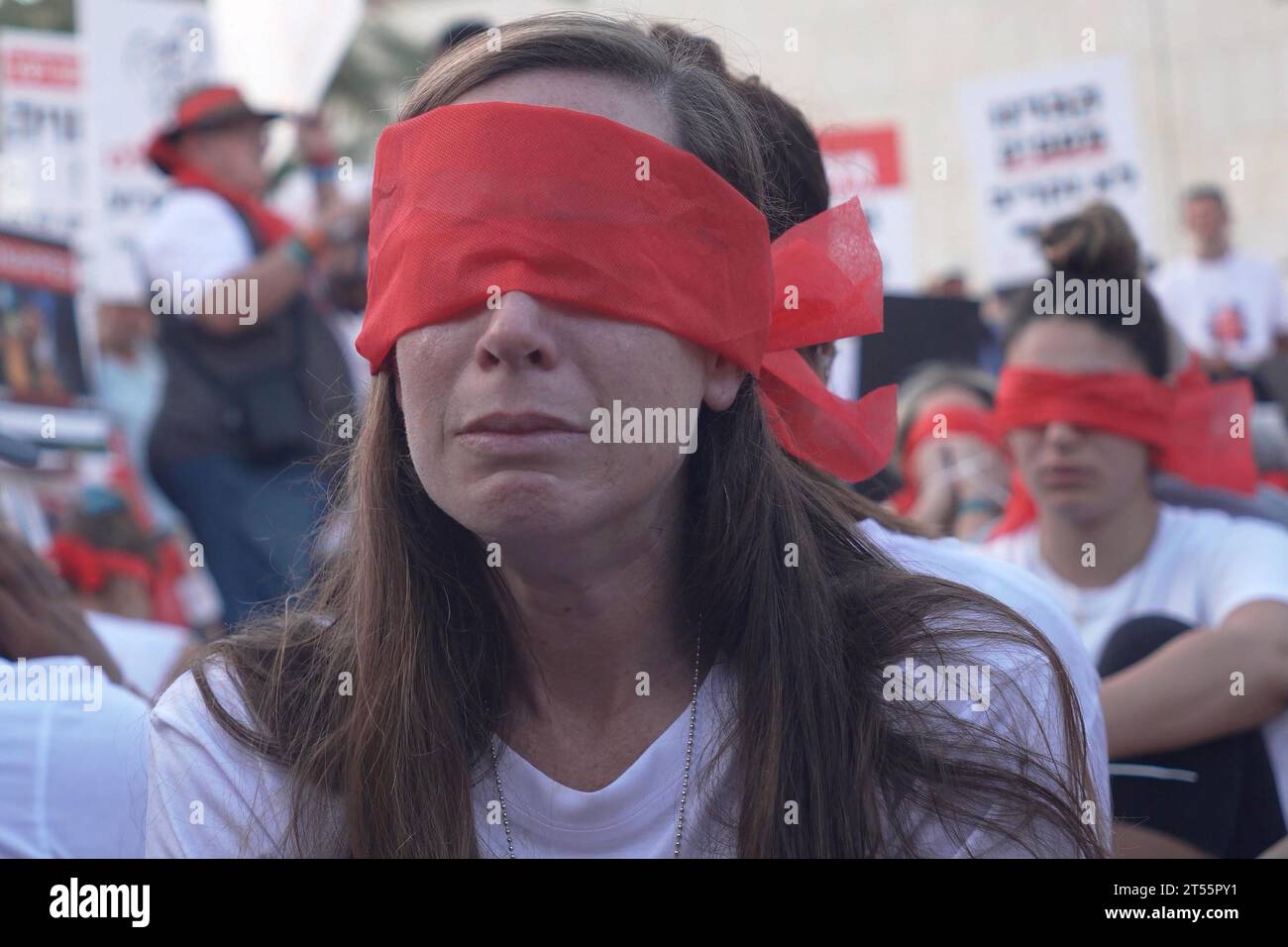 Una mujer llora mientras miembros de la comunidad kibutz de Kfar Aza se sientan atados y vendados los ojos durante una manifestación para destacar la difícil situación de los rehenes detenidos en Gaza, que fueron capturados en el ataque mortal del 7 de octubre por militantes de Hamas el 2 de noviembre de 2023 en Tel Aviv, Israel. Foto de stock