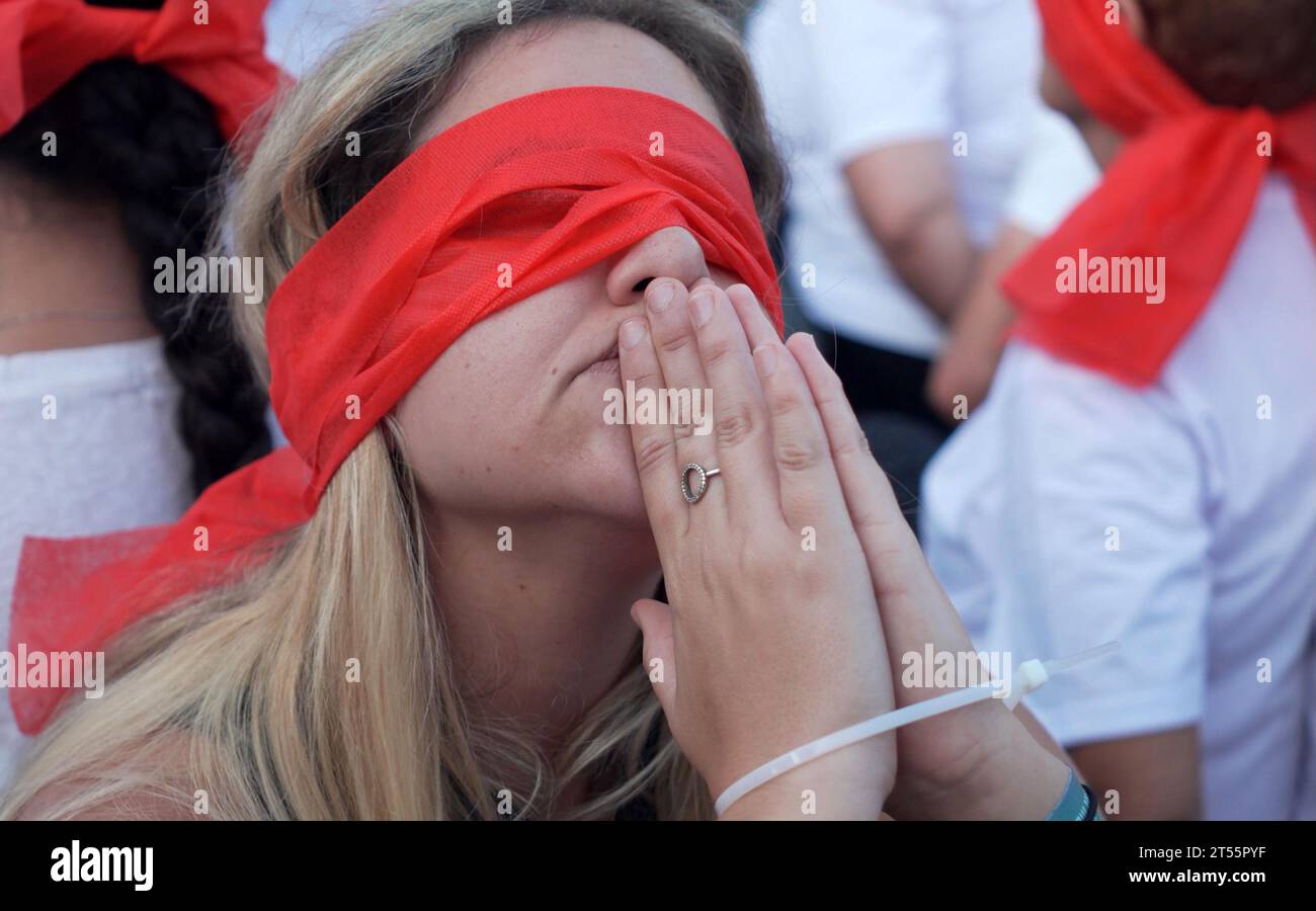 Miembros de la comunidad kibutz de Kfar Aza se sientan atados y vendados los ojos durante una manifestación para destacar la difícil situación de los rehenes retenidos en Gaza, que fueron capturados en el mortal ataque del 7 de octubre por militantes de Hamas el 2 de noviembre de 2023 en Tel Aviv, Israel. Foto de stock