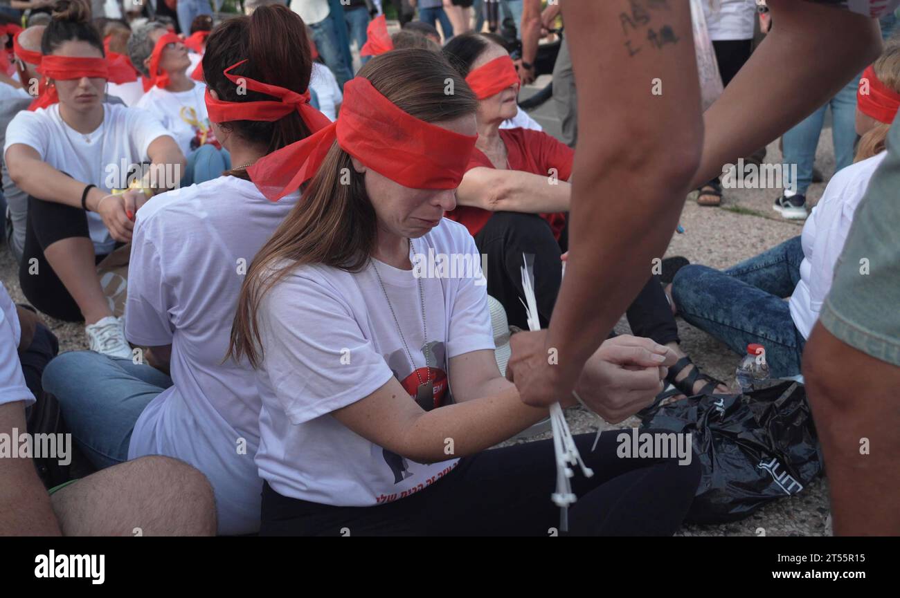 Una mujer llora mientras miembros de la comunidad kibutz de Kfar Aza se sientan atados y vendados los ojos durante una manifestación para destacar la difícil situación de los rehenes detenidos en Gaza, que fueron capturados en el ataque mortal del 7 de octubre por militantes de Hamas el 2 de noviembre de 2023 en Tel Aviv, Israel. Foto de stock