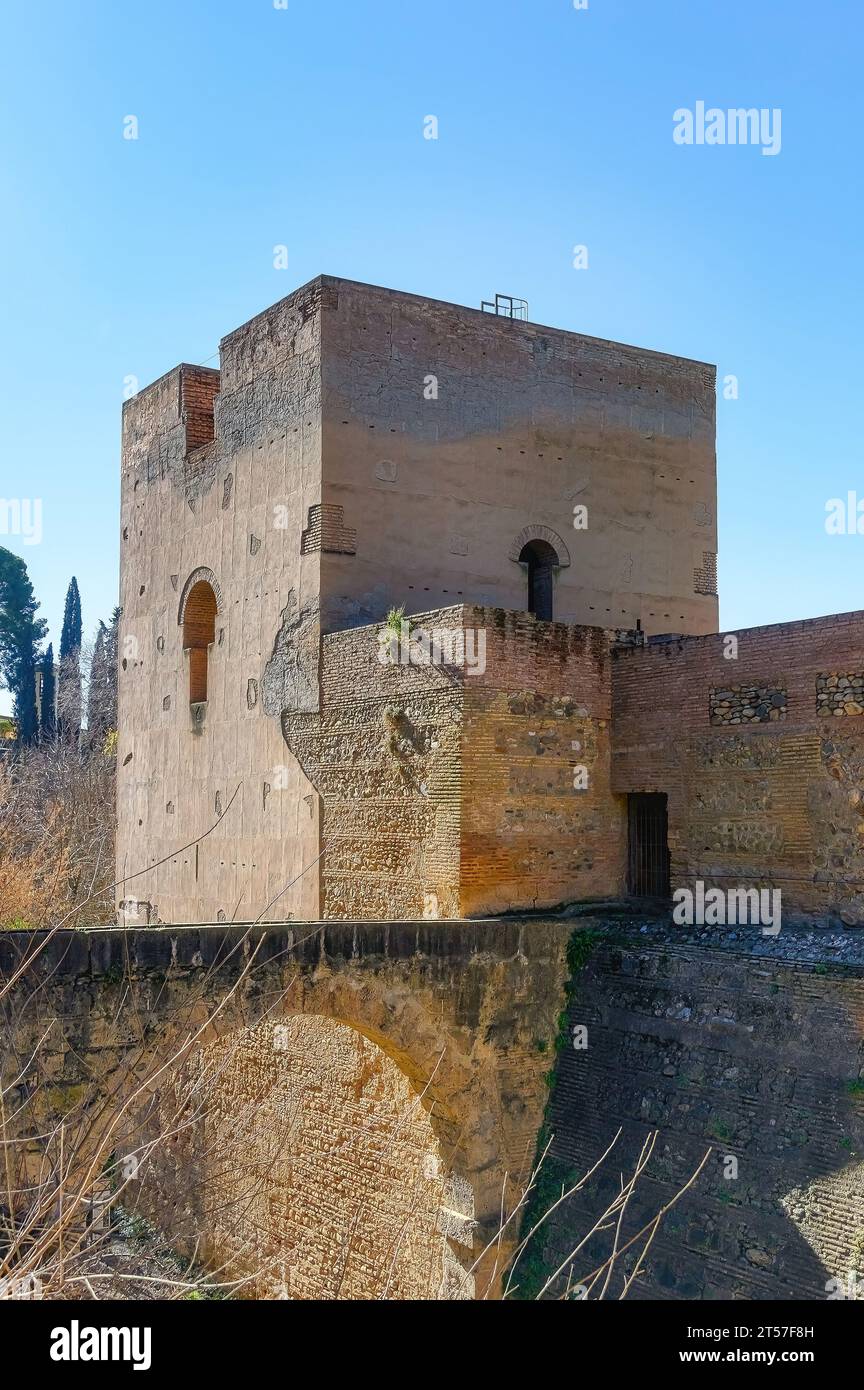 Granada, España, una estructura de arco de piedra sobre el foso en la fortaleza de la Alhambra o complejo de palacio. Un muro fortificado y una torre que muestra la arquitectura de estilo islámico. Foto de stock