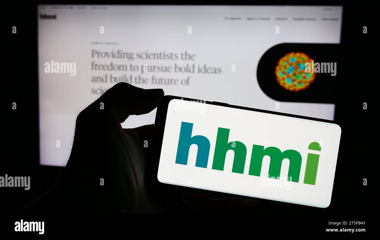 Persona que sostiene el teléfono celular con el logotipo de la