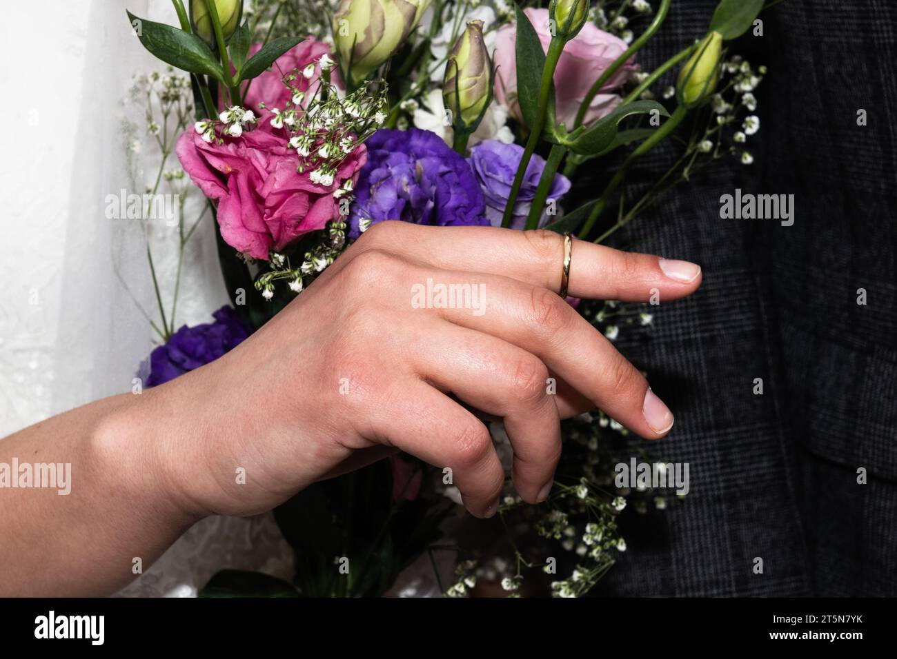 Una novia judía sostiene su dedo índice con el anillo en la mano de su novio durante una celebración de boda judía en Israel. Foto de stock