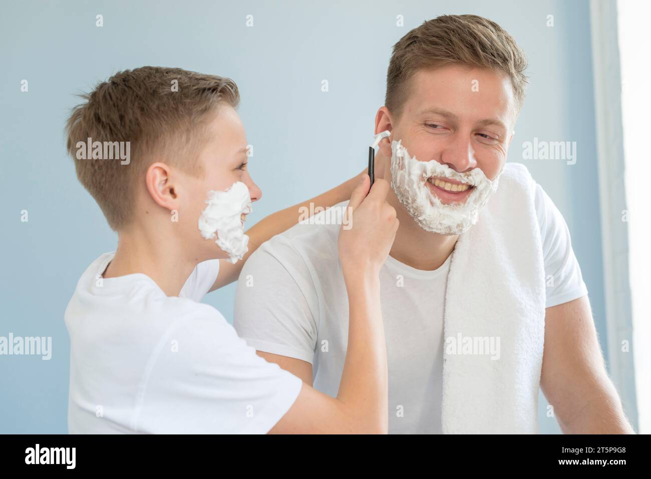 Hijo ayudando a su padre a afeitarse Foto de stock