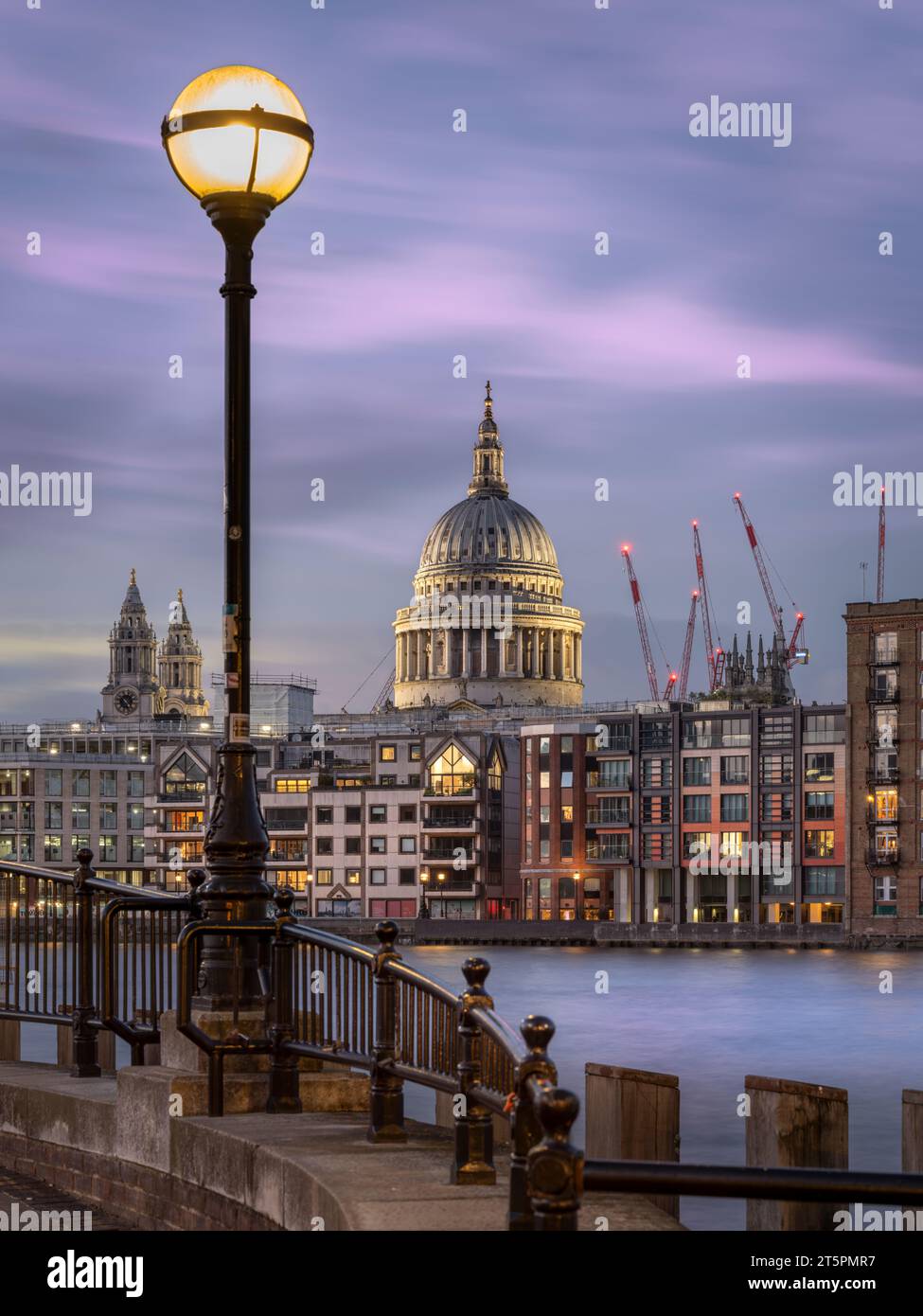 La cúpula distintiva de la Catedral de San Pablo domina el horizonte al atardecer, ya que las luces se encienden a lo largo de Bankside, al sur del río Támesis, Londres, en Foto de stock