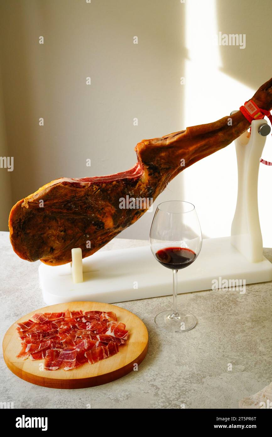 Jamon serrano español, tabla jamonera Cuchillo Jamonero, con vidrio y una  botella de vino. Foto de alimentos concepto Fotografía de stock - Alamy