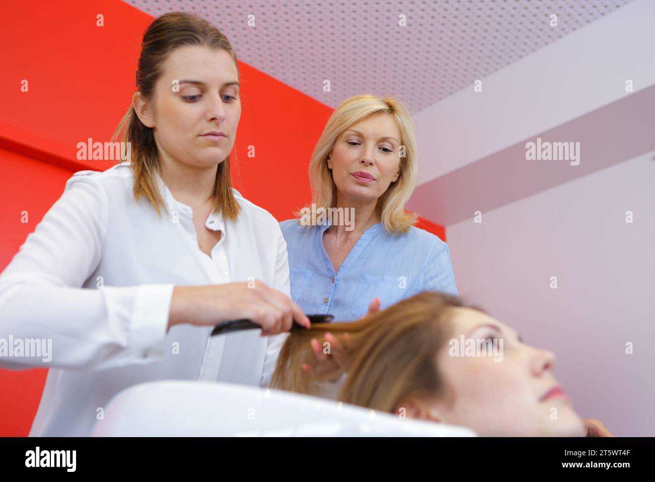 mujer recibiendo un mal corte de pelo en el salón Foto de stock