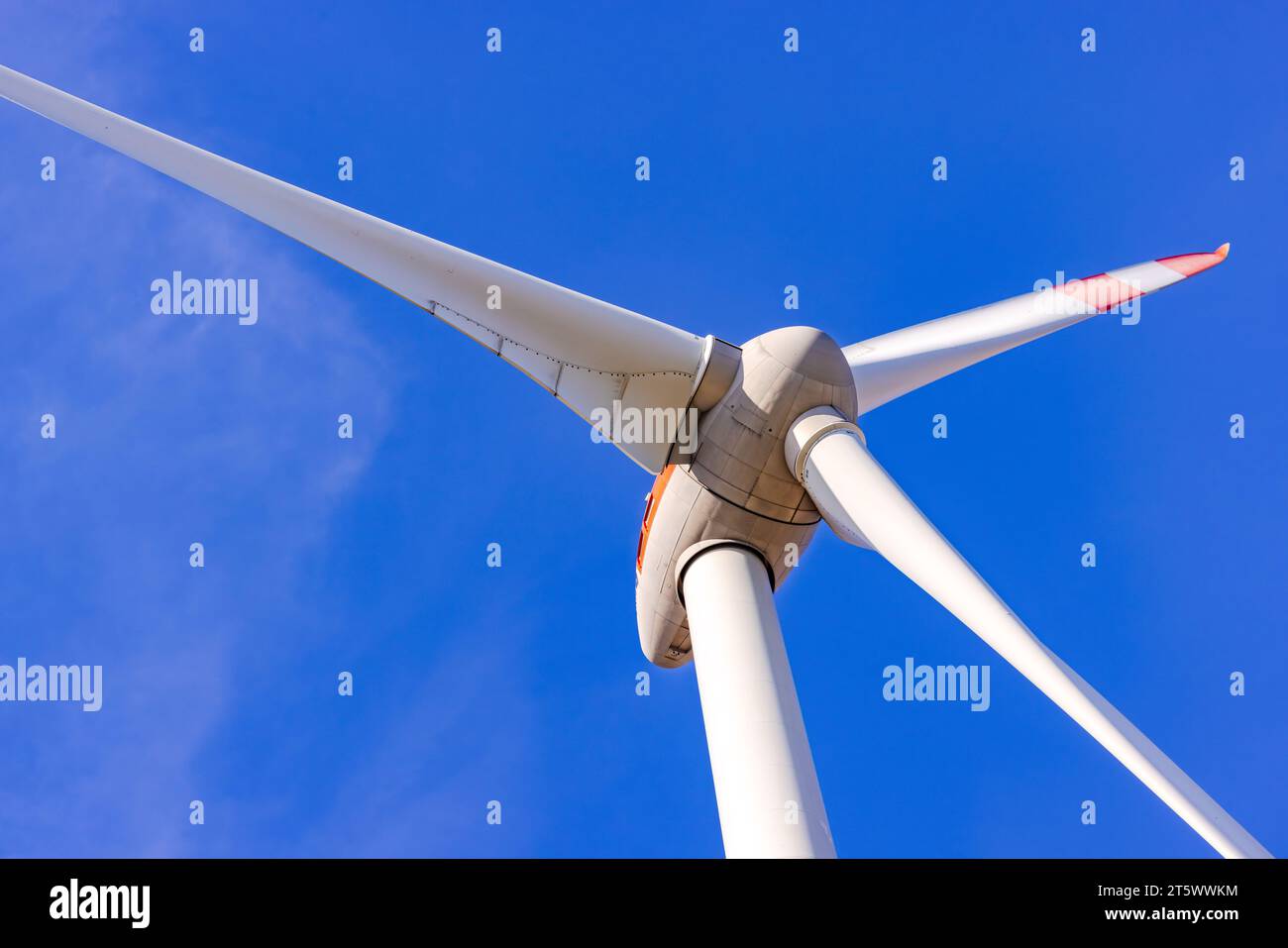 Detalles del rotor y las palas de una turbina de viento recortadas frente a un cielo azul Foto de stock