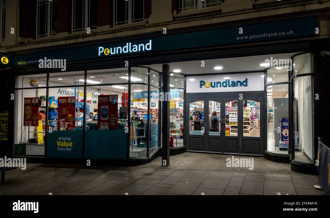 Tienda de conveniencia Poundland iluminada por la noche, High Street, Lincoln City, Lincolnshire, Inglaterra, REINO UNIDO Foto de stock