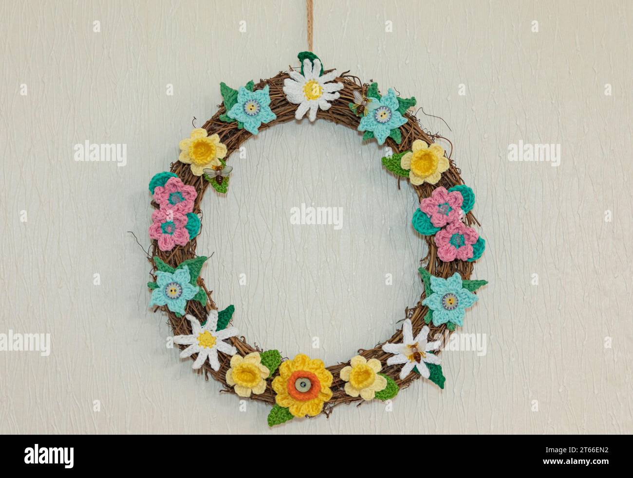 Anillo hecho de crochet de flores de primavera y verano con abejas y rafia Foto de stock