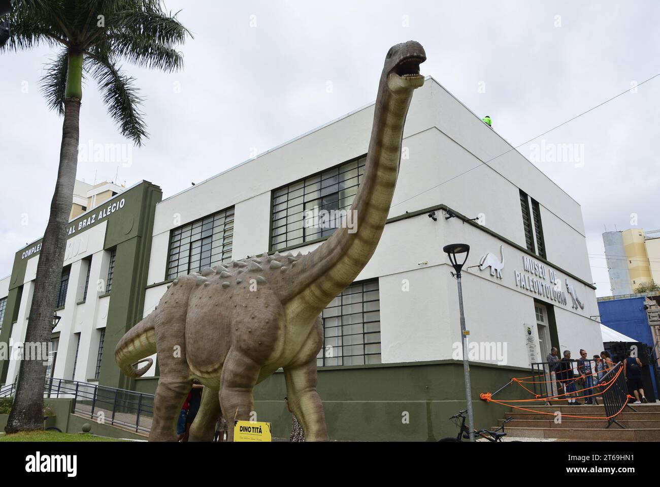 Fiesta de cumpleaños de la ciudad con una réplica de dinosaurio titán junto al Museo de Paleontología Foto de stock