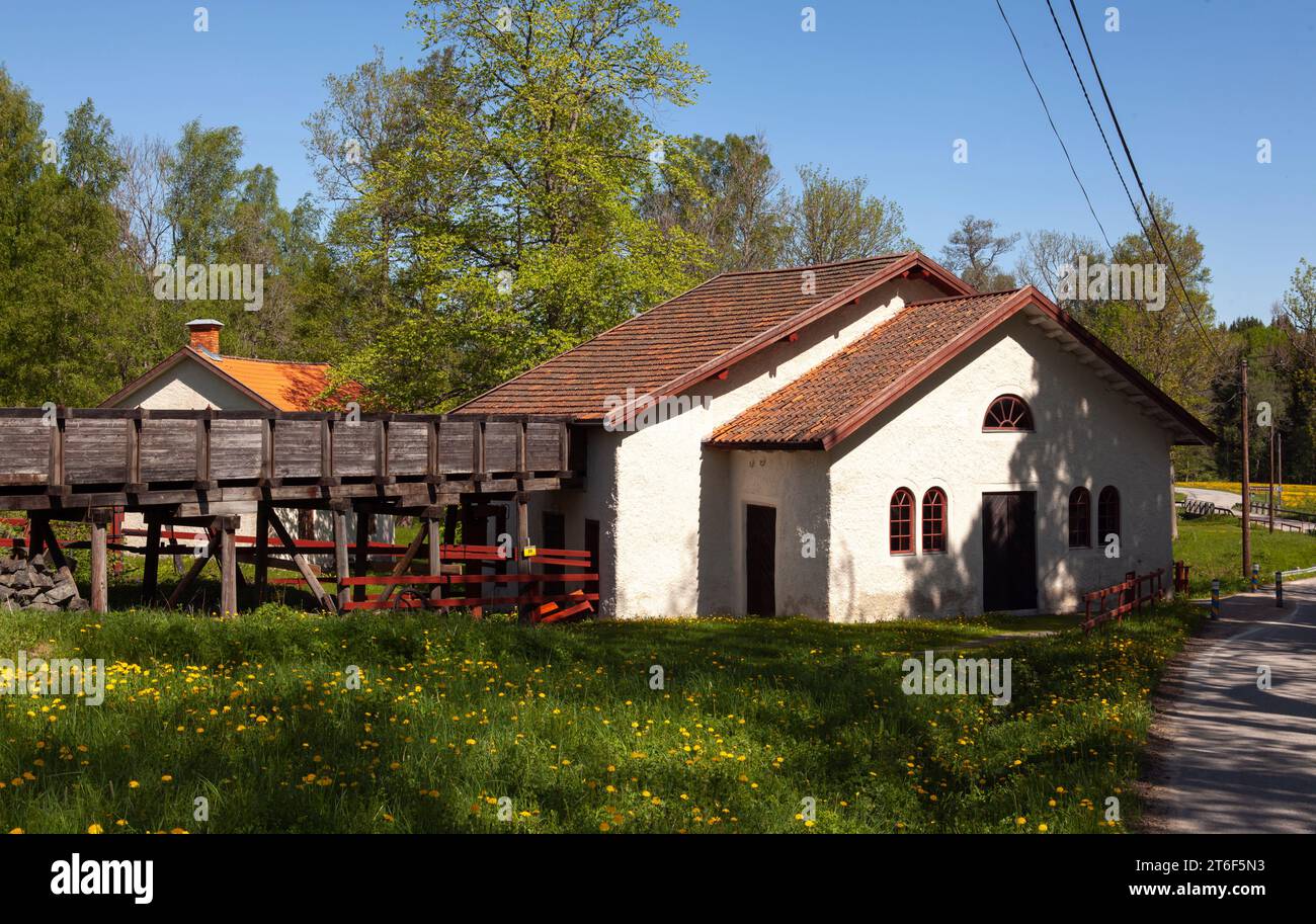 El edificio blanco donde tienen lugar la rueda de agua y la transmisión de energía en la antigua fundición de hierro. Monumento cultural. Foto de stock