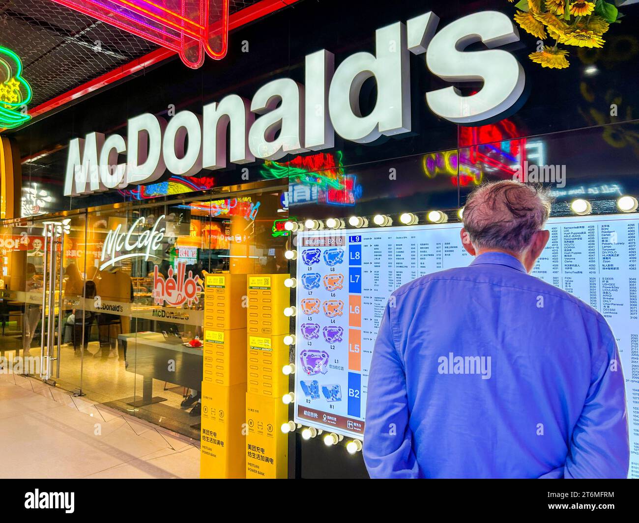 Shanghái, China, Barrio de negocios, Hombre mayor desde atrás, signo de menú de lectura, frente al restaurante de comida rápida McDonald's, centro de la ciudad de GOME (rama cambiante), capitalismo de china Foto de stock