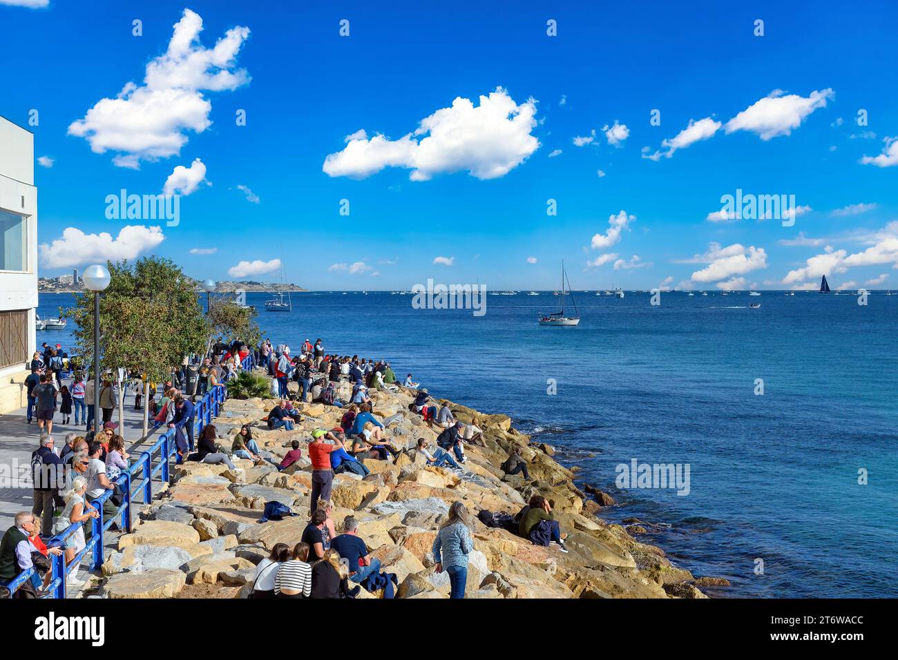 Alicante, España, gente en la costa viendo la línea de salida del evento anual Ocean Race. Foto de stock