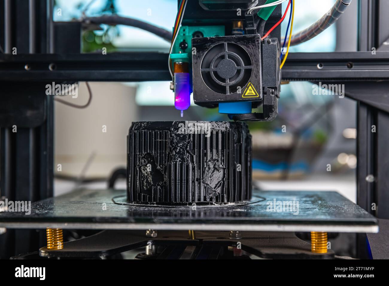Una impresora 3D imprime un modelo negro. Tecnología en casa Foto de stock