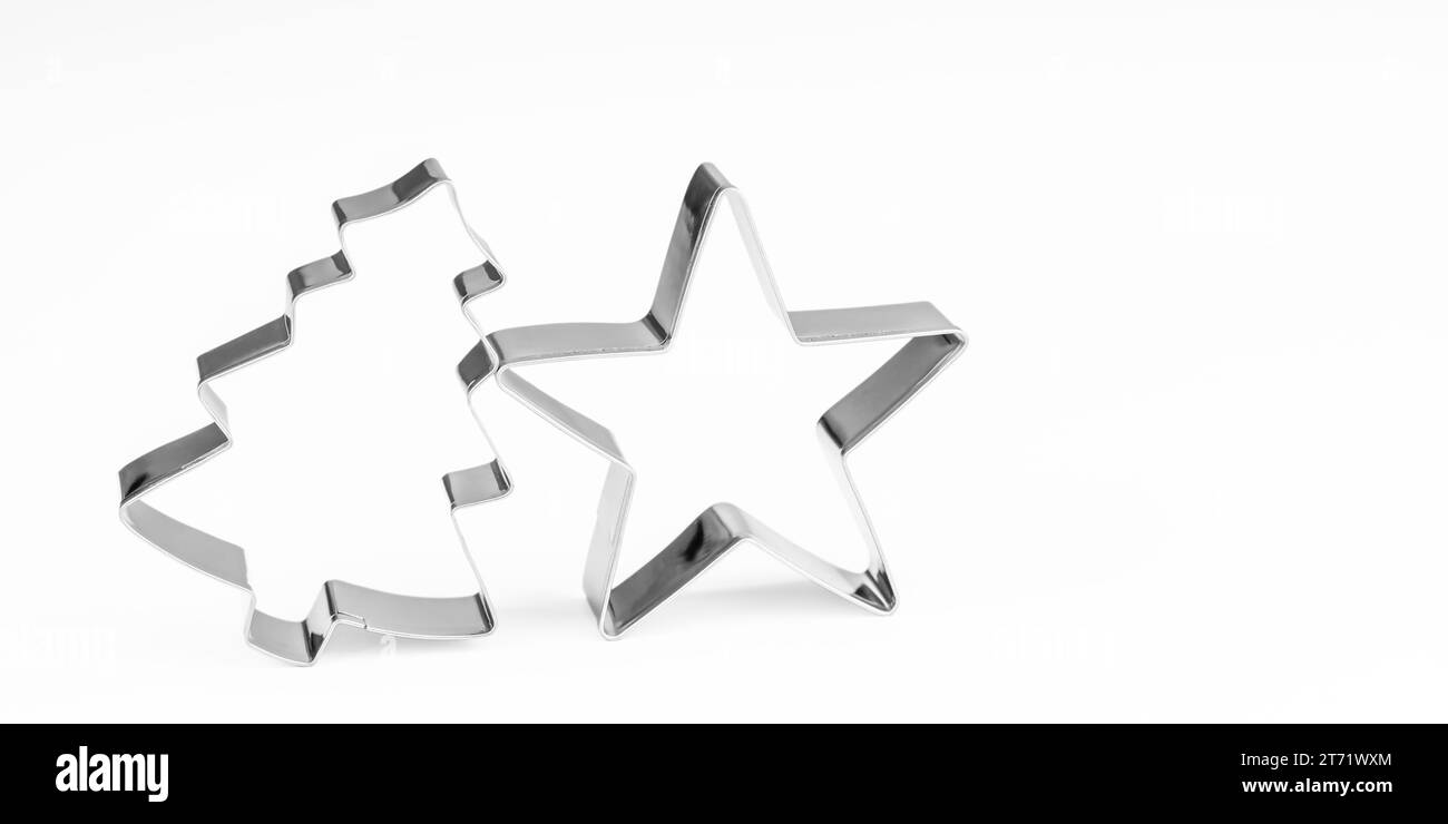 Cortadores de galletas de forma de estrella y árbol. Estrella de metal en blanco y árbol aislados sobre fondo blanco Foto de stock