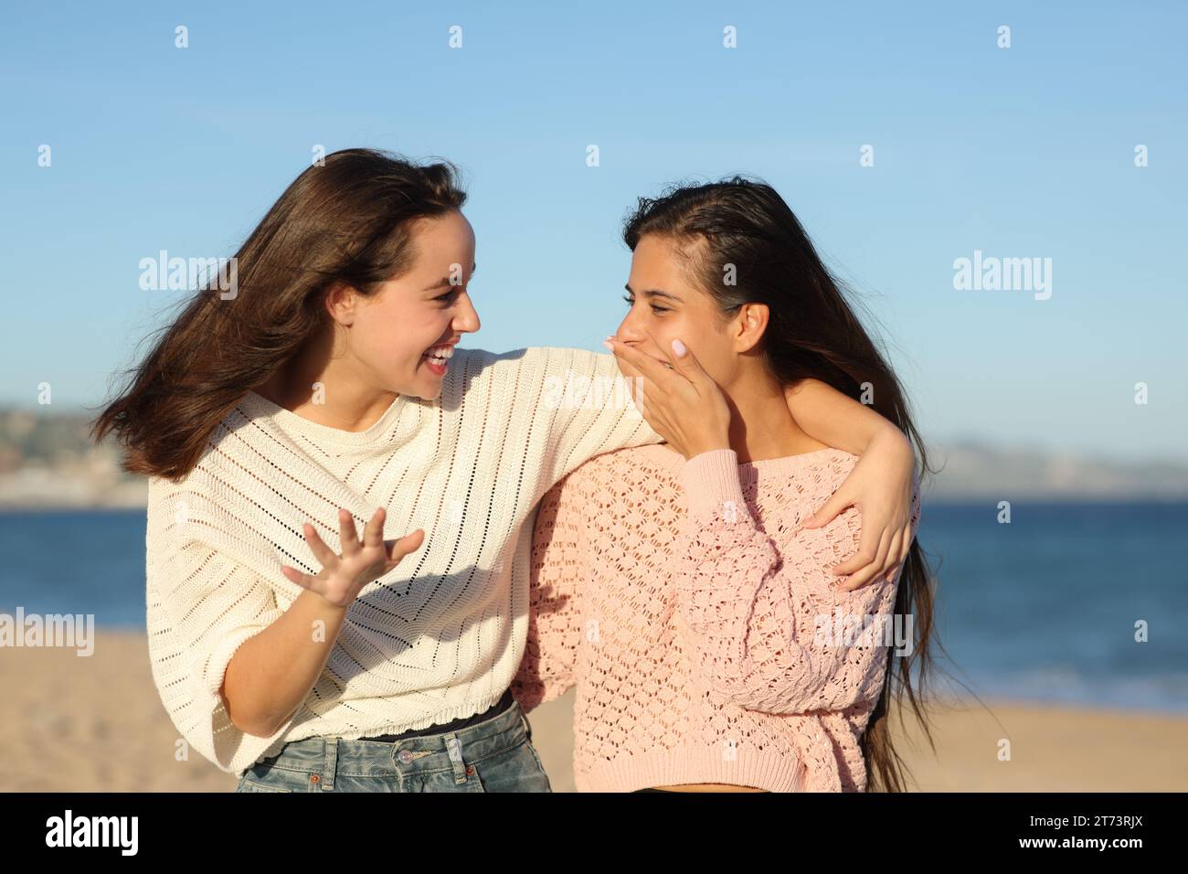 Chismes amigos hablando y contando anécdota sorprendente en la playa Foto de stock