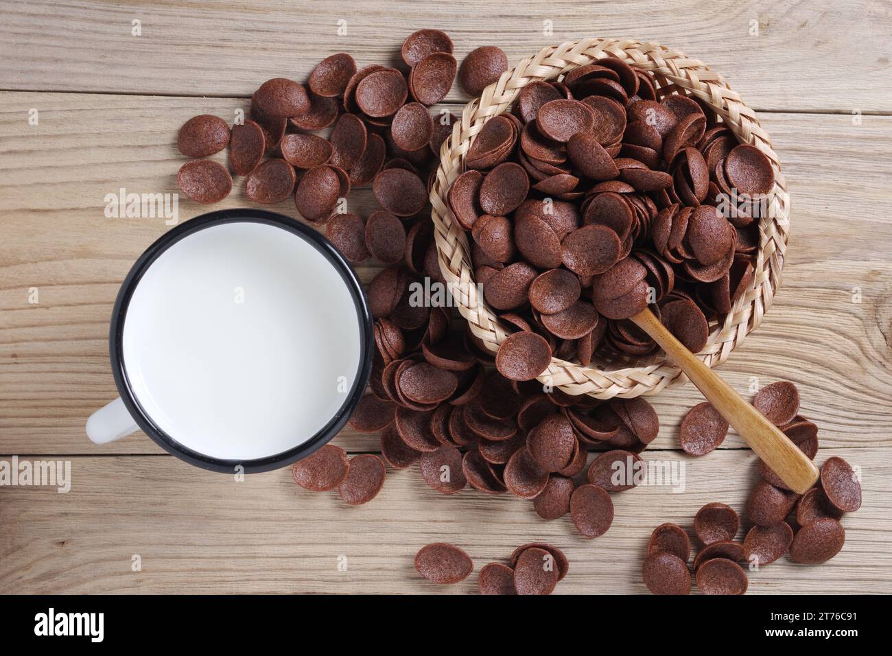 Taza de esmalte de leche y copos de maíz de chocolate sobre fondo de madera, vista superior Foto de stock