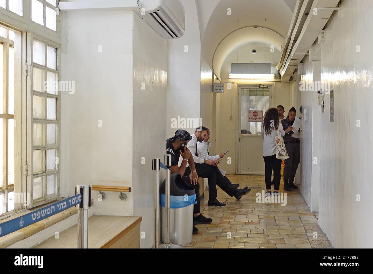 Un funcionario del Servicio Penitenciario de Israel habla con un abogado en un pasillo frente a una sala del Tribunal de Primera Instancia de Jerusalén el 13 de noviembre de 2023 en Jerusalén, Israel. Foto de stock
