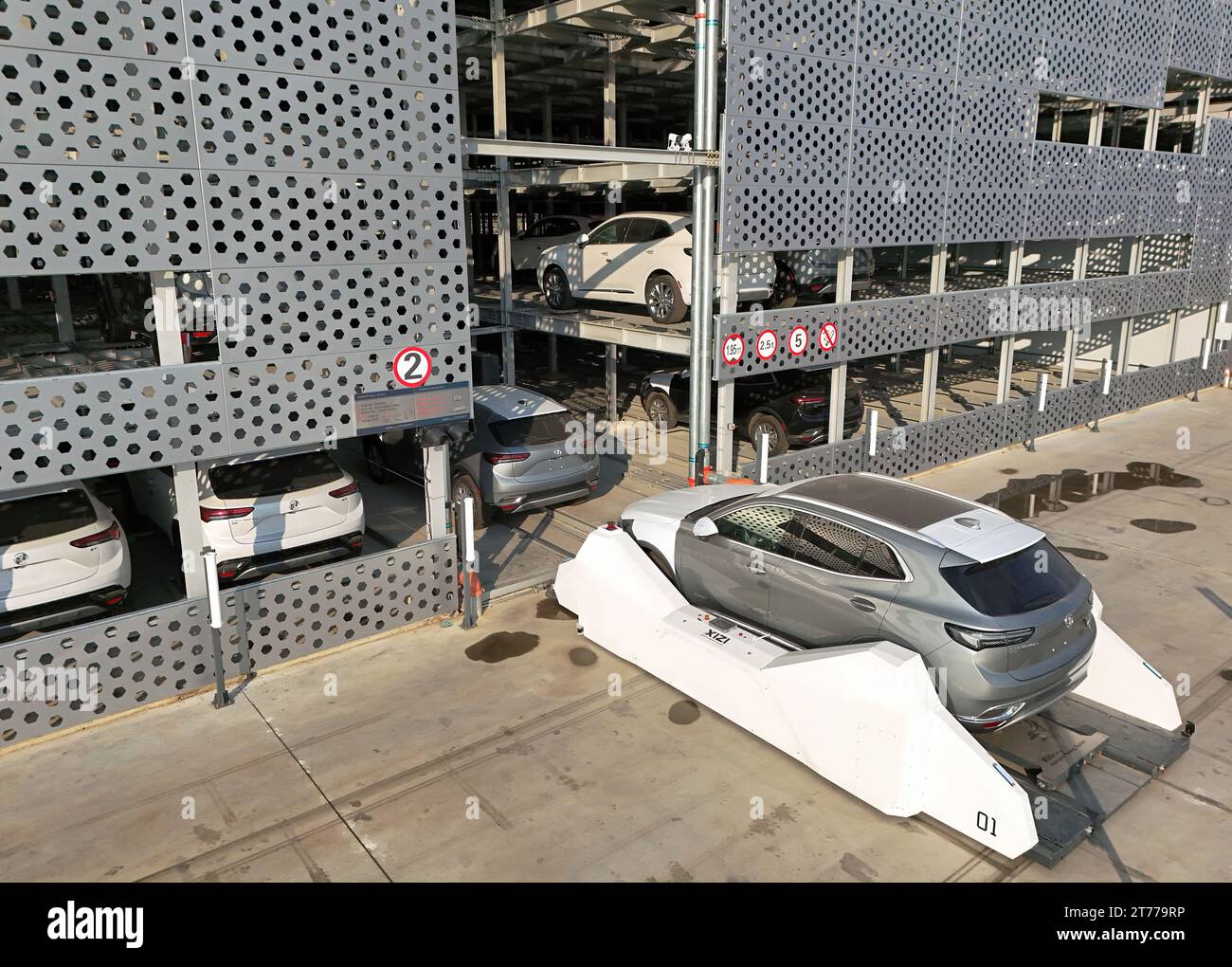 YANTAI, CHINA - 13 DE NOVIEMBRE de 2023 - AGV (Automated Guided Vehicle) transfiere vehículos comerciales desde el almacén a la zona de entrega en el compositor Foto de stock
