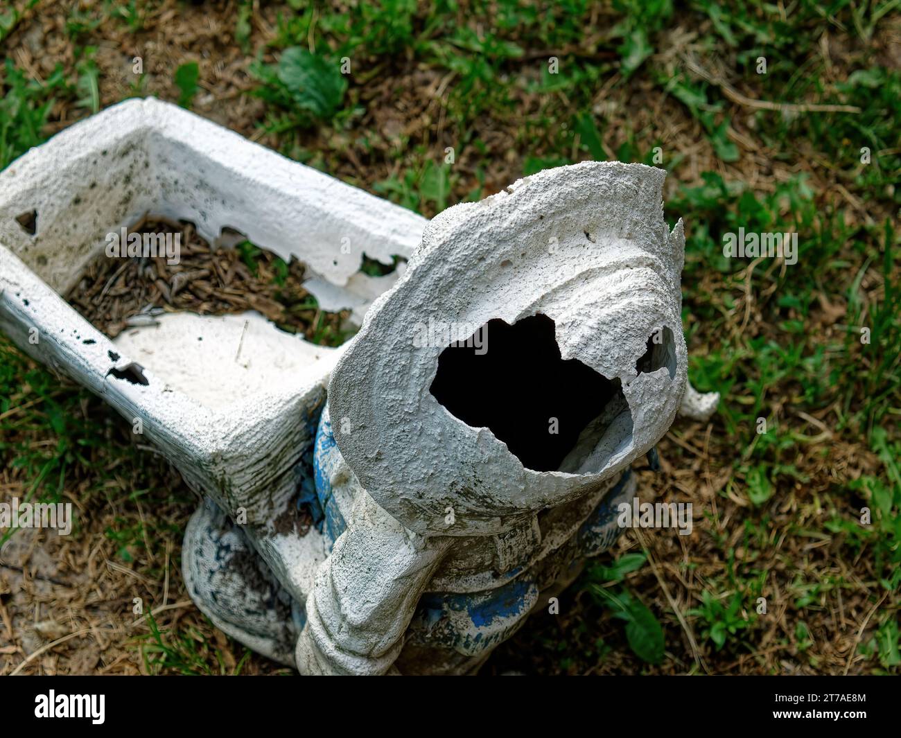 Antigua figura de gnomo de jardín roto, en el jardín Foto de stock