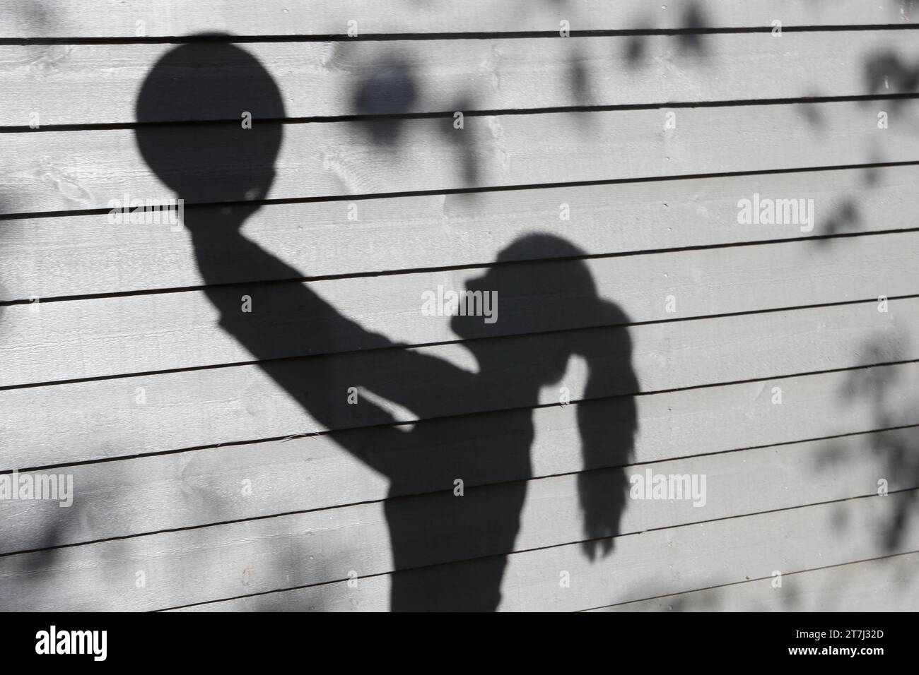 Chica adolescente sostiene voleibol con ambas manos sombra sosteniendo la bola en copyspace Foto de stock