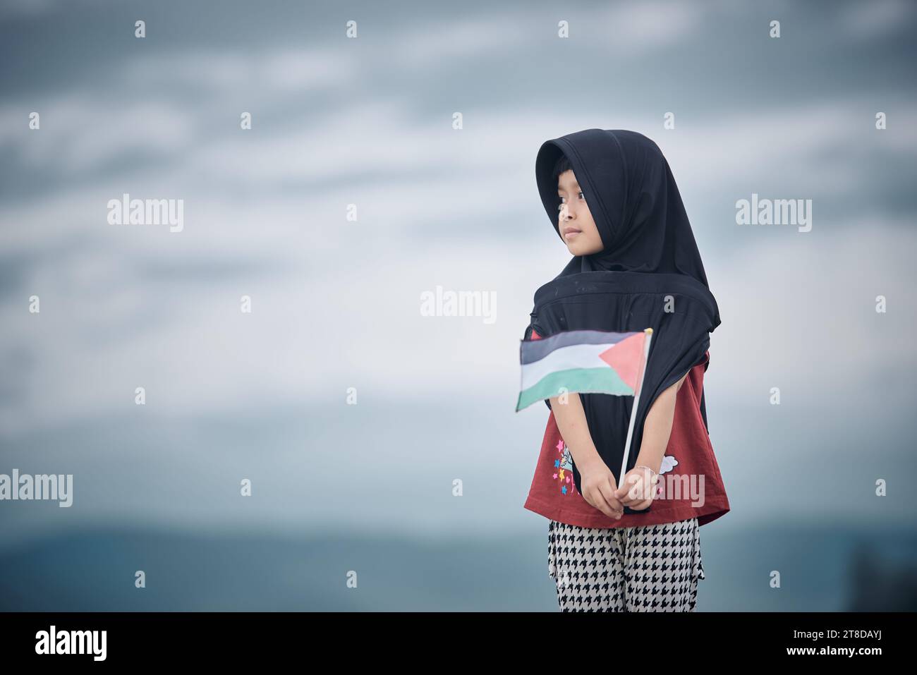 Linda niña ondeando bandera palestina envía un poderoso mensaje de apoyo y empatía al mundo Foto de stock