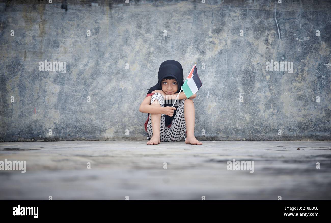 Linda niña ondeando bandera palestina envía un poderoso mensaje de apoyo y empatía al mundo Foto de stock