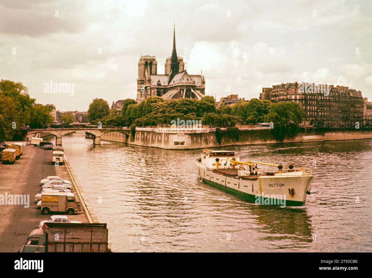 Barco de carga en el río Sena con la catedral de Notre Dame en el fondo, París, Francia, principios de los años 1960 Foto de stock