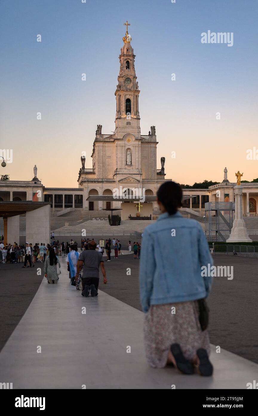 Personas que caminan por el Sendero penitencial de rodillas hacia la Capilla de las Apariciones. Santuario de Nuestra Señora del Rosario de Fátima en Fátima, Portugal. Foto de stock