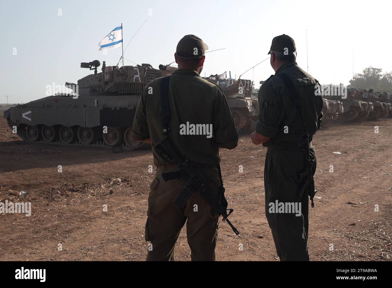 Los soldados israelíes están junto a los tanques Merkava estacionados cerca de la frontera con la Franja de Gaza en medio de batallas en curso entre Israel y Hamás el 23 de noviembre de 2023 en el sur de Israel. Más de un mes después de los ataques de Hamás el 7 de octubre, el ejército del país ha continuado su bombardeo sostenido de la Franja de Gaza y ha lanzado una invasión terrestre para derrotar al grupo militante que gobierna el territorio palestino. Foto de stock