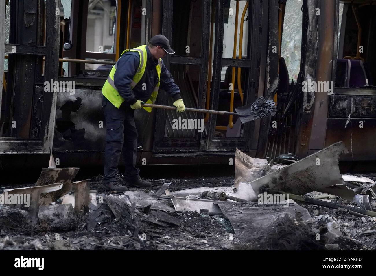 Los escombros son limpiados de un Luas y un autobús quemados en la calle O'Connell en Dublín, después de escenas violentas en el centro de la ciudad el jueves por la noche. Los disturbios se produjeron después de un ataque en Parnell Square East, donde cinco personas resultaron heridas, incluidos tres niños pequeños. Fecha de la foto: Viernes 24 de noviembre de 2023. Foto de stock