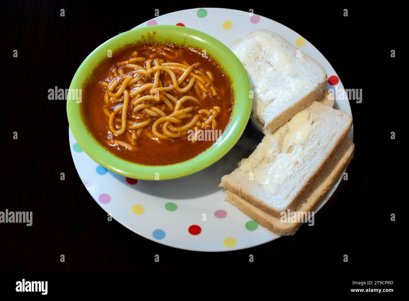 Espaguetis boloñés de una lata servida en un bol con rebanadas de pan y mantequilla para un almuerzo fácil Foto de stock