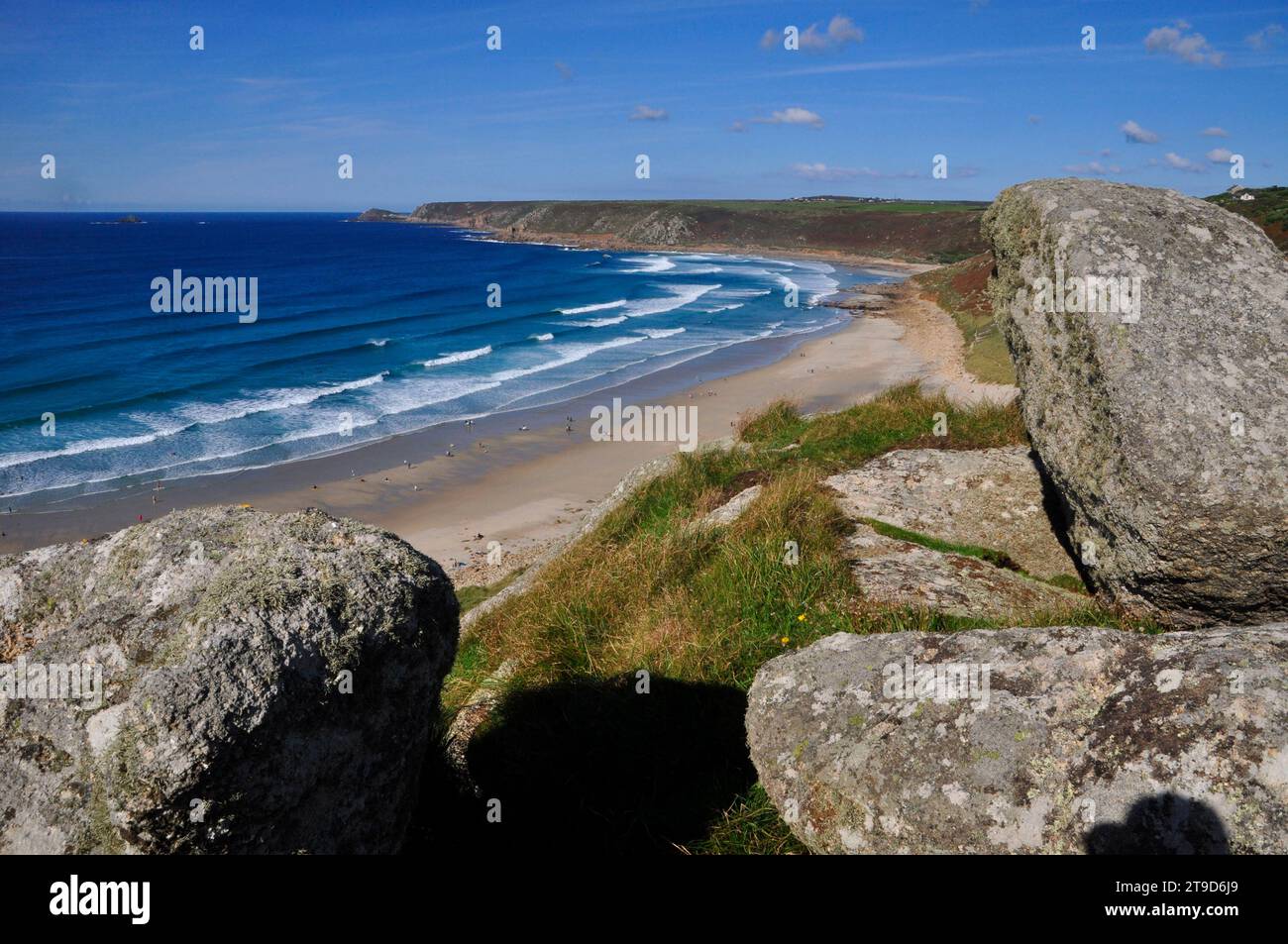 Visto entre rocas de granito en la cima de los acantilados, el hermoso barrido de la bahía Whitesand en Sennen Cove cerca de las tierras terminan con Cape Cornualles en la fa Foto de stock