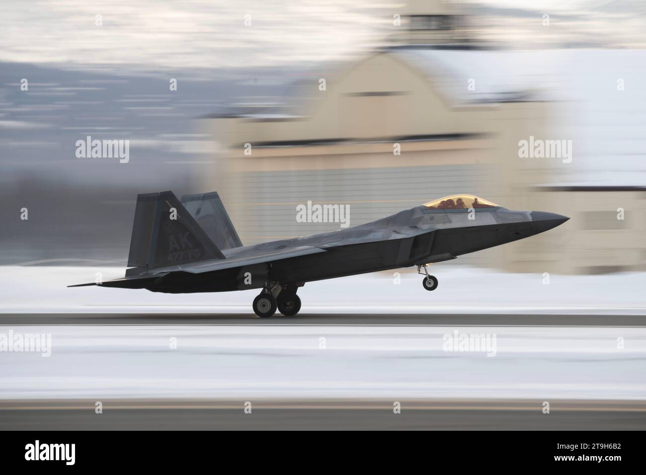 Anchorage, Estados Unidos. 21 de noviembre de 2023. Un avión de combate F-22 Raptor de la Fuerza Aérea de los Estados Unidos asignado a la 3ª Ala realiza operaciones de vuelo frente a un campo de cobertura de nieve en la Base Conjunta Elmendorf-Richardson, el 21 de noviembre de 2023 en Anchorage, Alaska. Crédito: Alejandro Pena/Planetpix/Alamy Live News Foto de stock