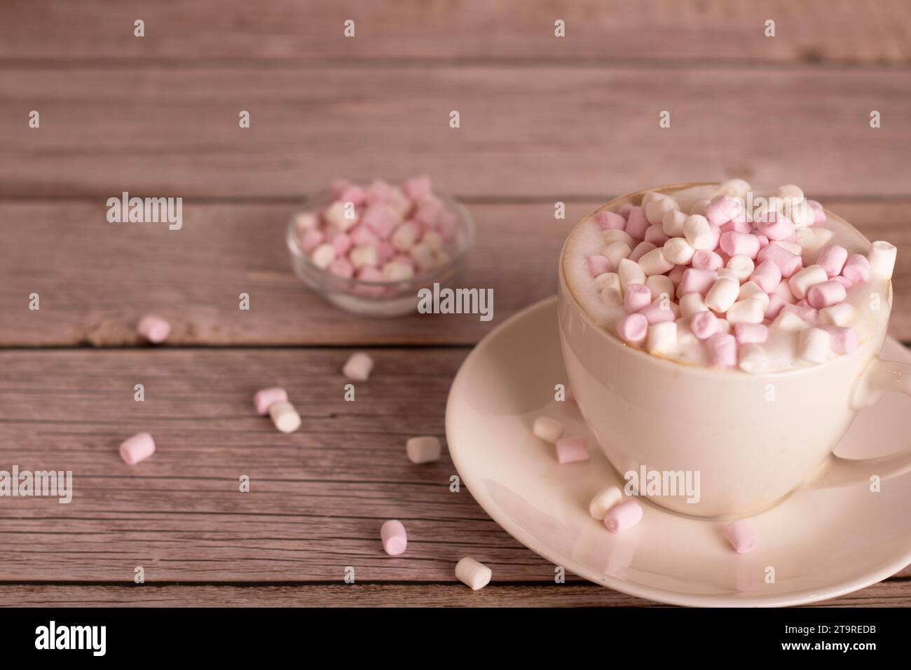 foto postre dulce, malvavisco blanco y rosa se encuentra en una taza de café con espuma, primer plano, hay un espacio vacío, sabroso, cálido, dulces, mesa, bocadillos Foto de stock